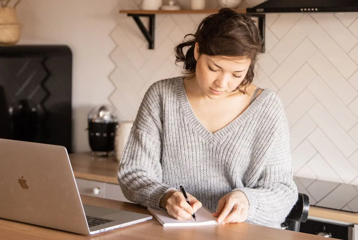 A woman is writing something down
