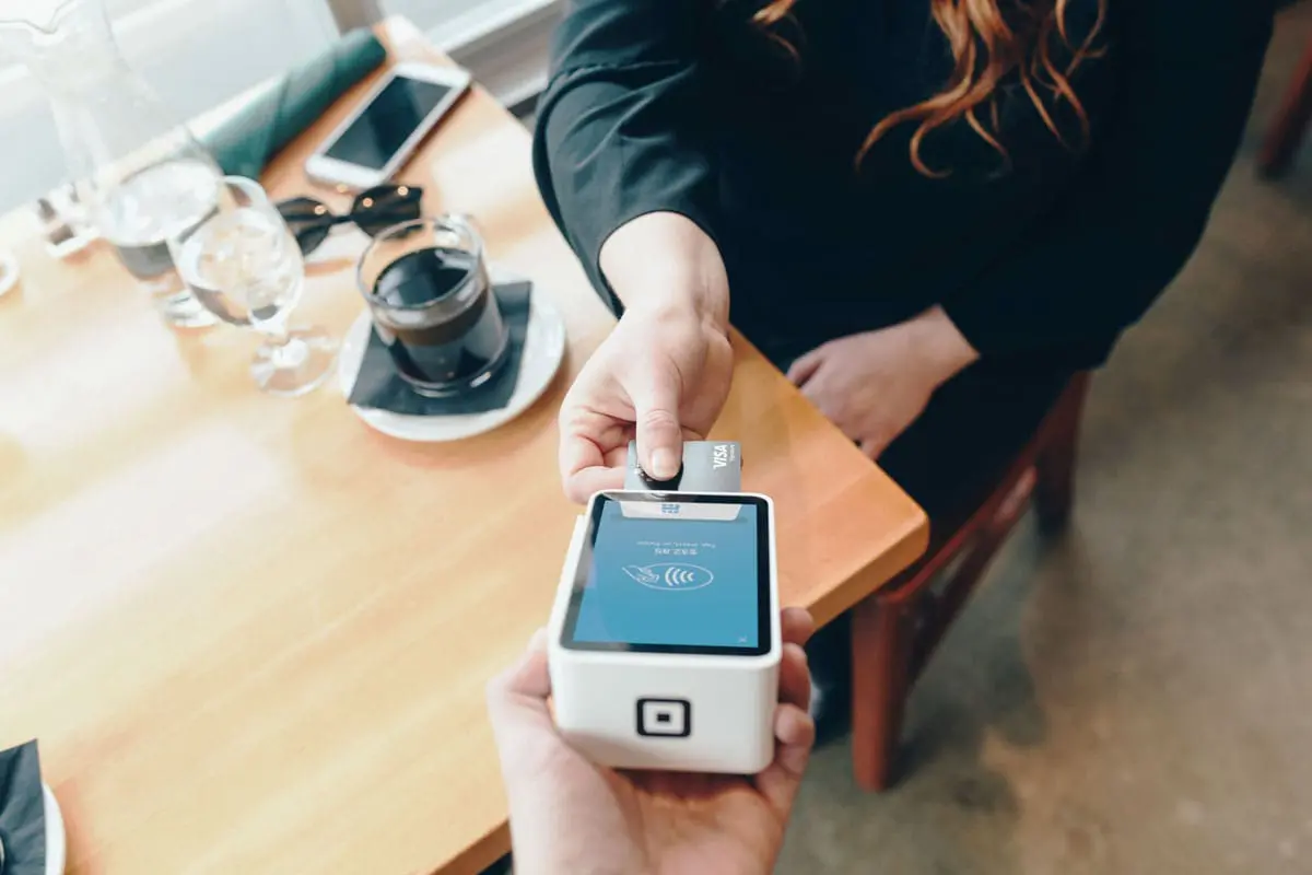 Someone is paying for coffee using a Secured Visa Credit Card