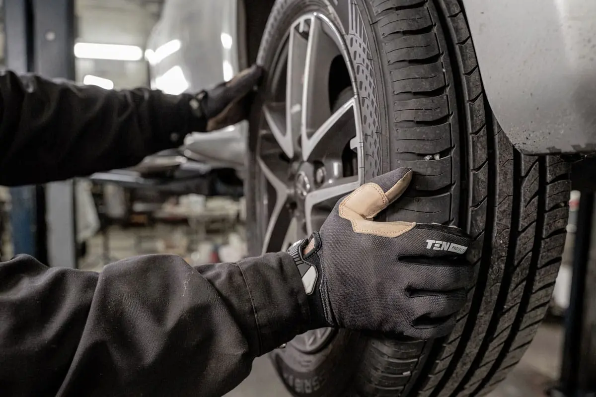 A mechanic is putting a tire on a car