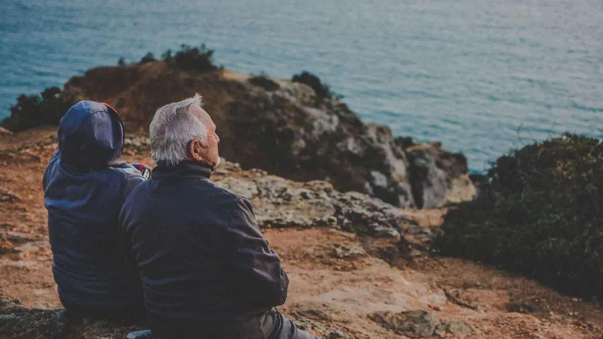 An older coupe is looking out at the ocean