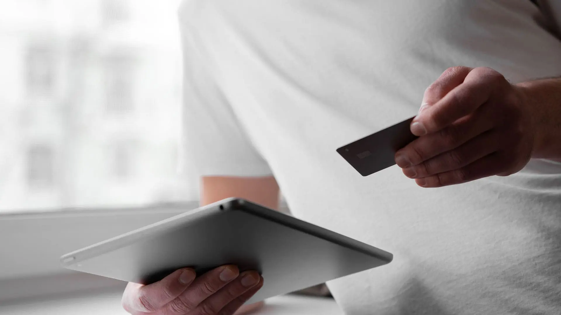 A person is using their iPad to enter a credit card number