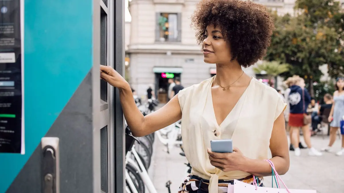 A woman is using an ATM outside