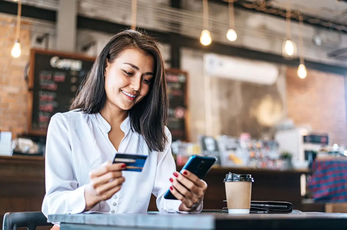 A woman is scanning a QR code to pay for her bill