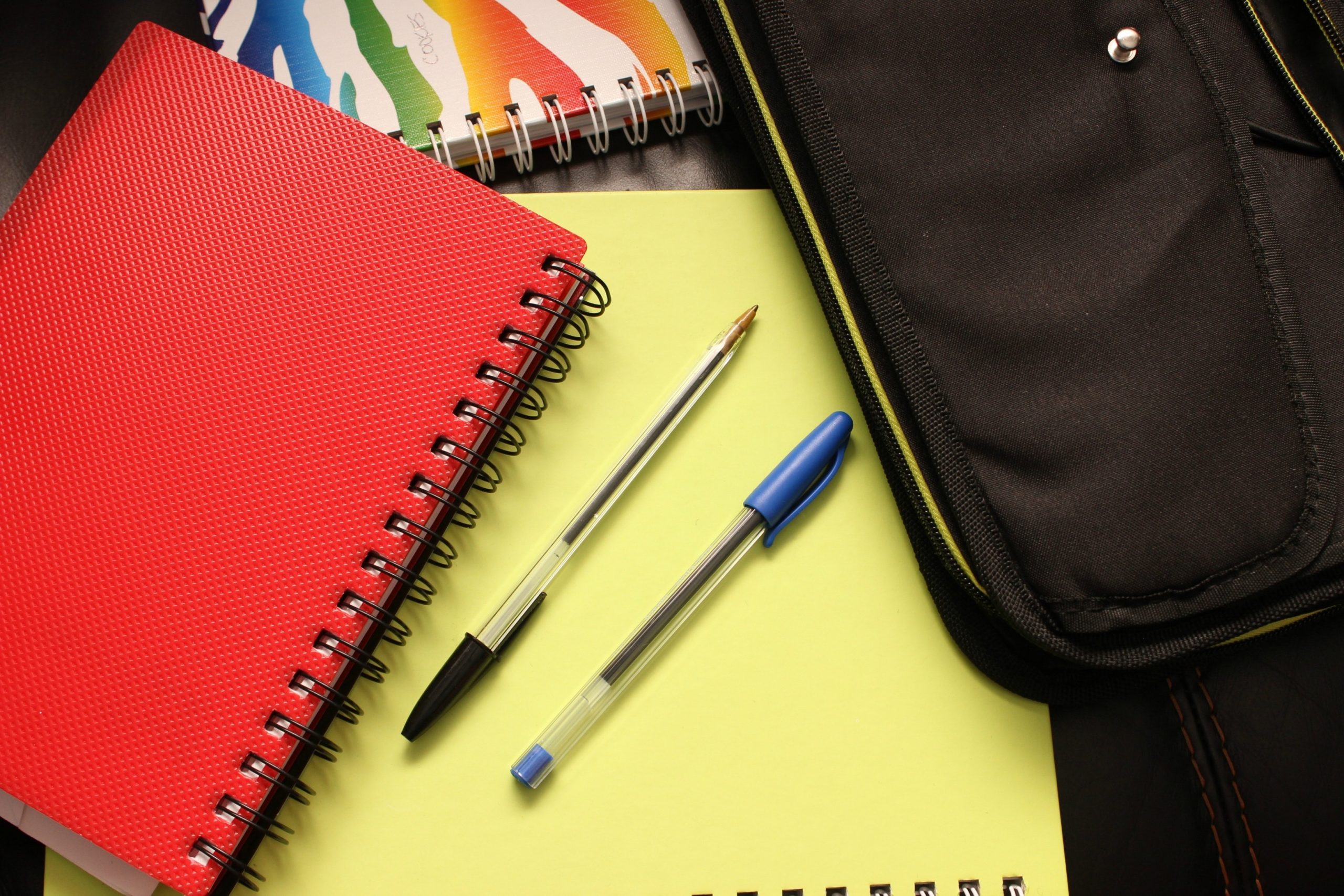 If you or your children are going back to school on a budget, there are many ways to save money on school supplies. This is closeup of notebooks and pens.