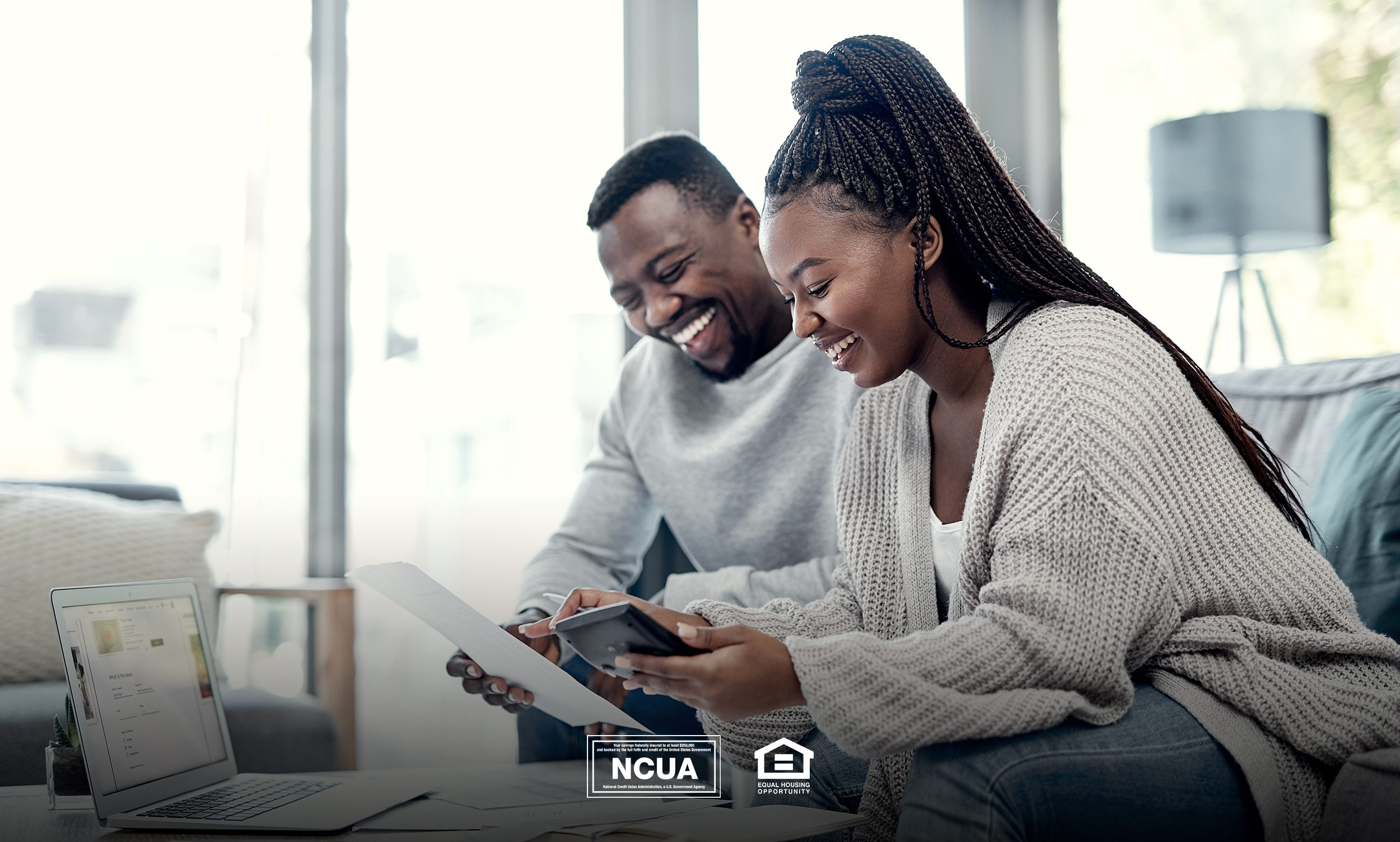 Homeowners can use home equity loans to their advantage. In this image, a happy couple are assessing their finances in their home.
