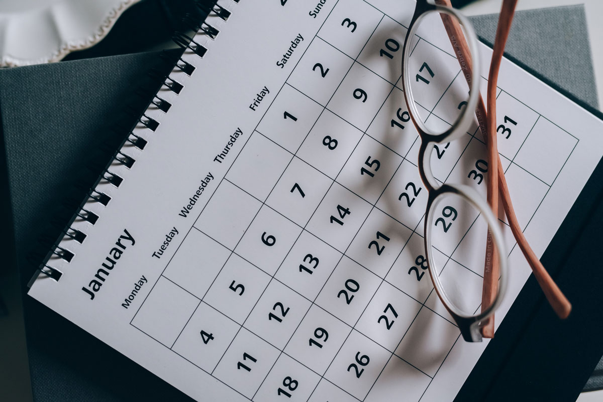 A pair of glasses resting on a calendar