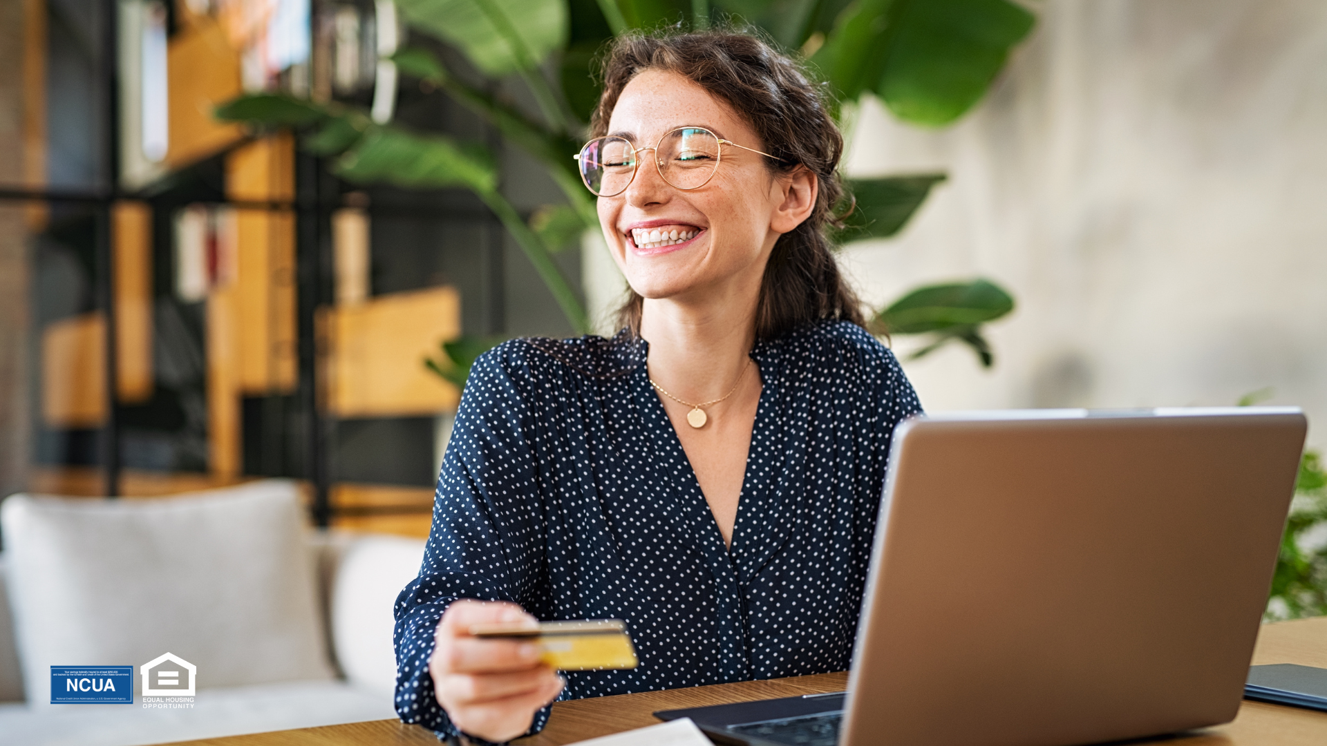 A person smiling while holding a credit card using Buy Now, Pay Later.
